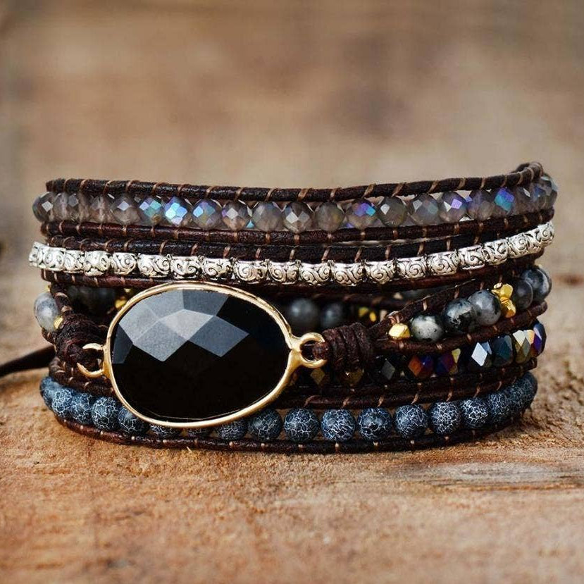 Multistrand beaded bracelet with gemstones on a wooden surface.