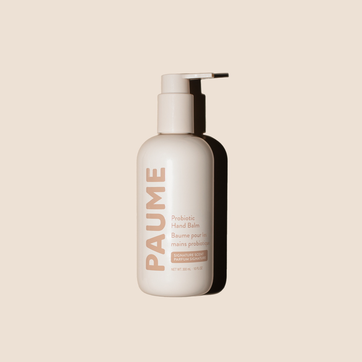 A PAUME Probiotic Hand Balm bottle in a matte off-white finish with a matching pump dispenser, set against a solid light beige background.