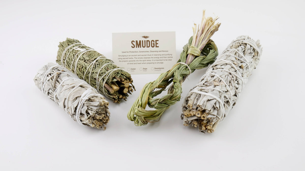 Assorted smudge bundles displayed with a printed smudging instruction card