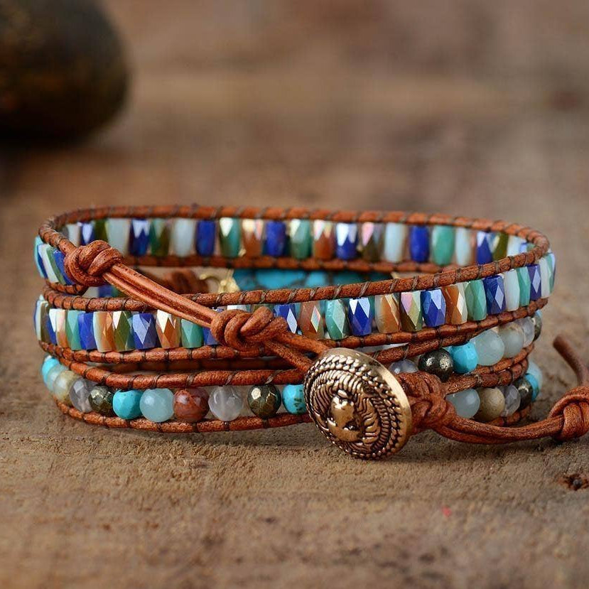 Multicolored beaded bracelet with a brown leather strap on a wooden surface