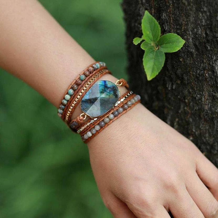 Bracelet with a large blue gemstone on a wrist against a natural background