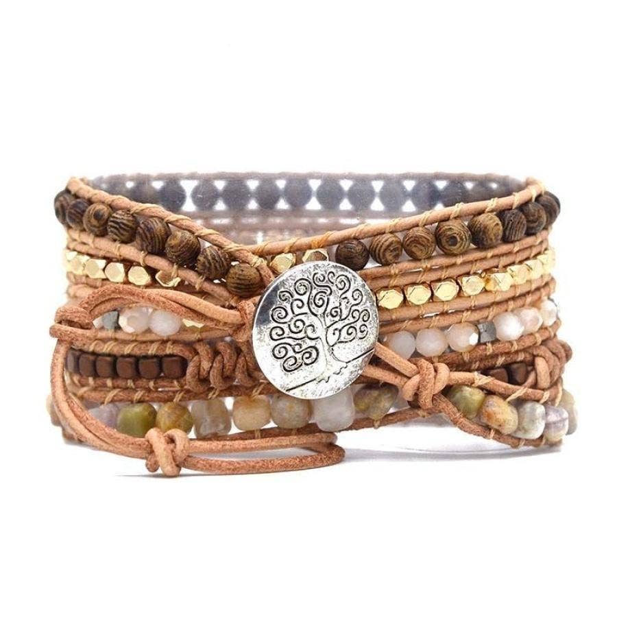 Multistrand beaded bracelet with a central silver tree-of-life button on a white background