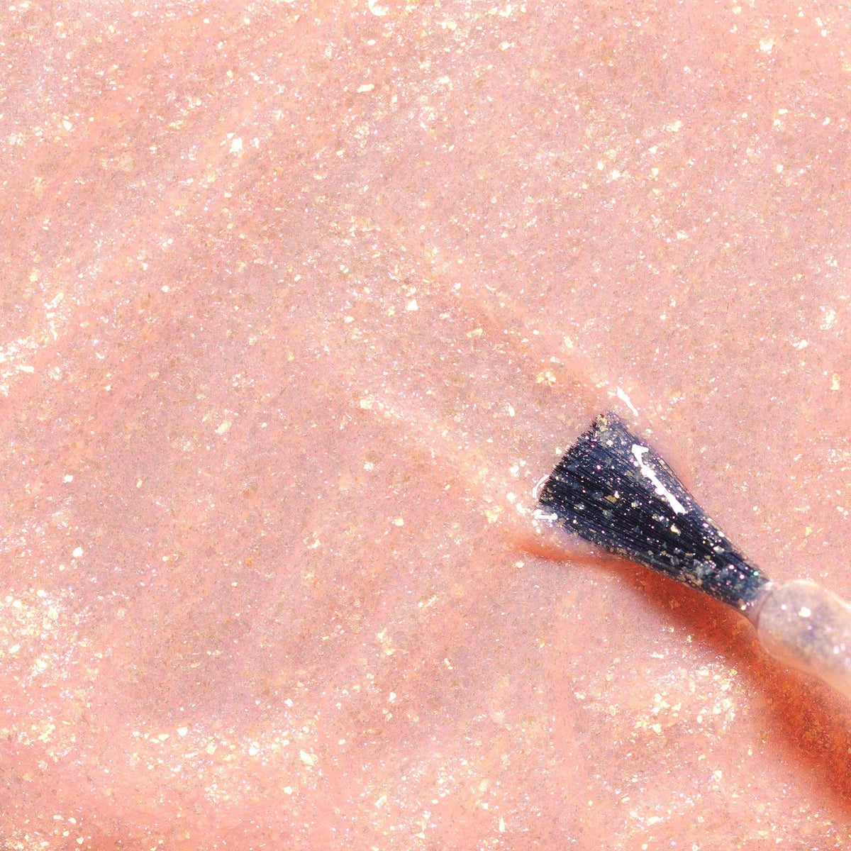 Stella pale pink glitter nail polish with a brush on a pink shimmer background