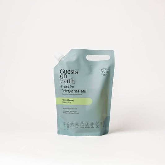 Guests on Earth Green Hinoki Laundry Detergent bulk refill pouch on a white surface.