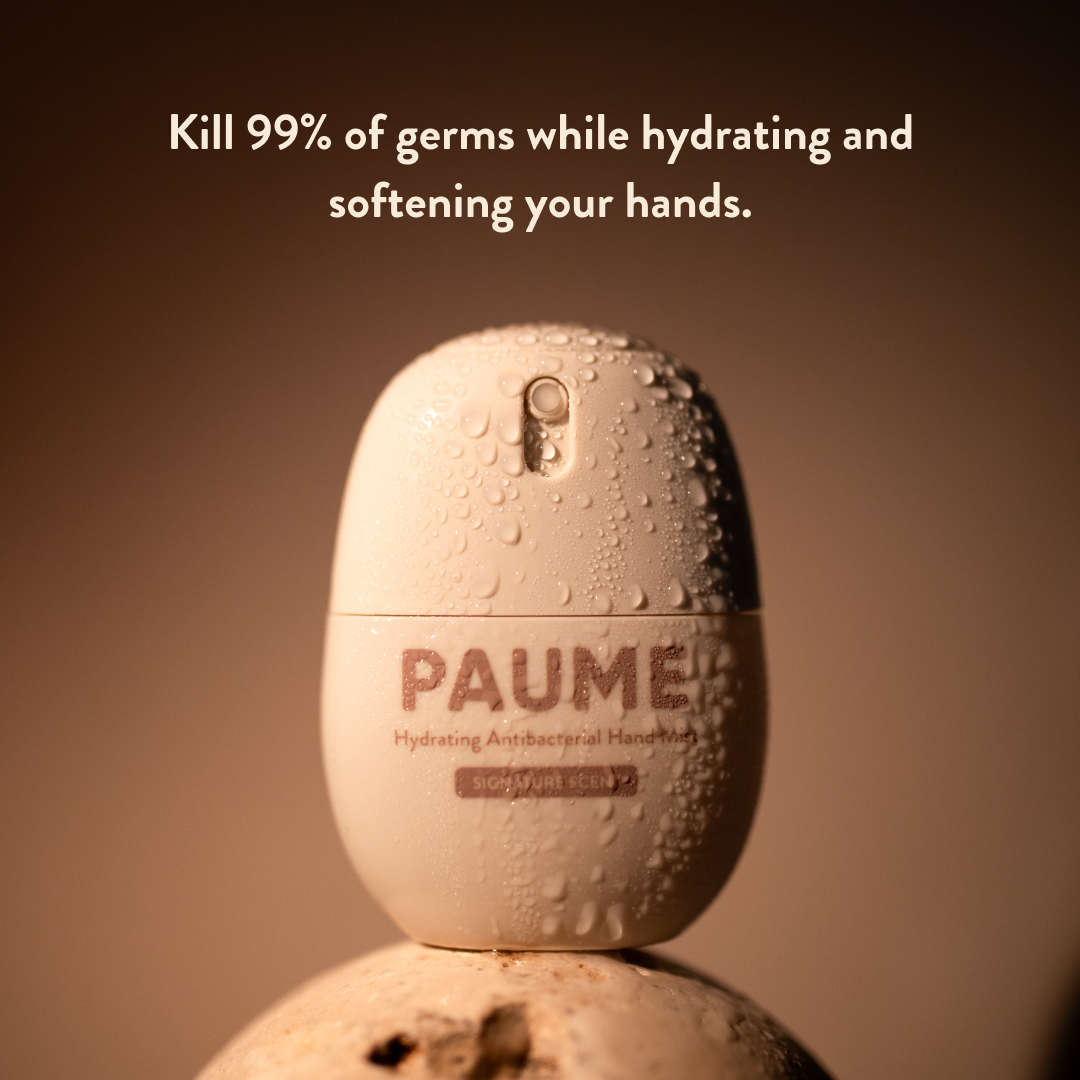 PAUME hand sanitizer bottle with text on a brown background