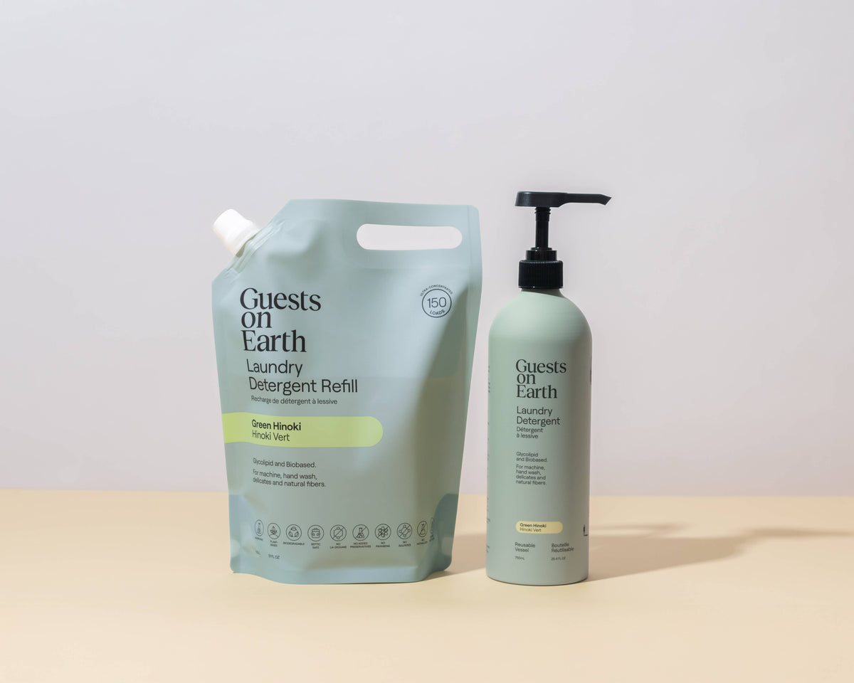 Guests on Earth Green Hinoki Laundry Detergent refill pouch beside its reusable pump bottle.