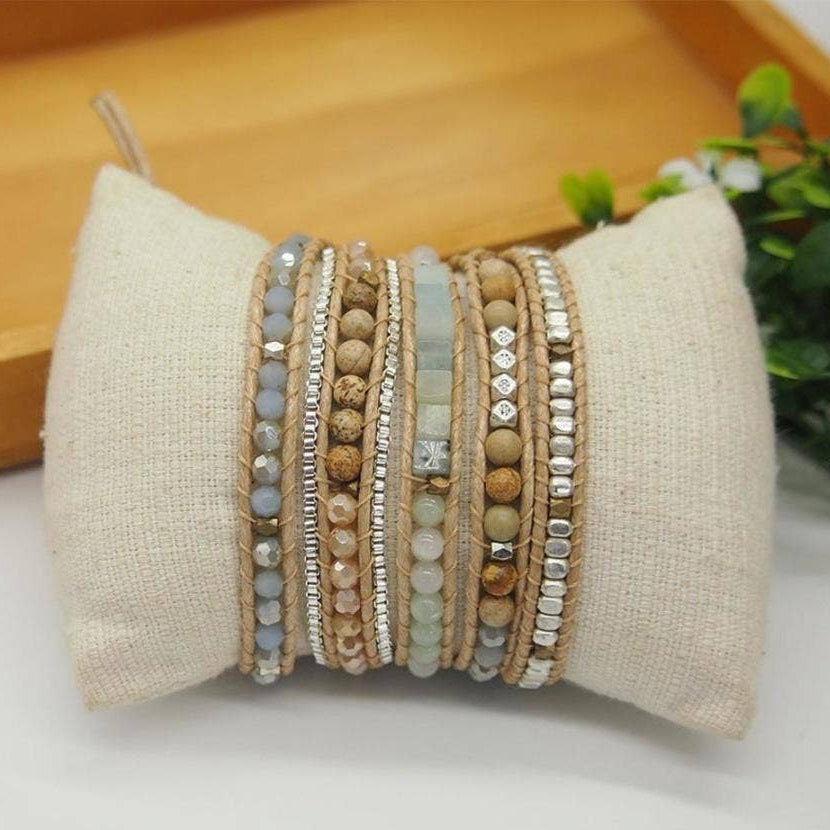 Stack of beaded bracelets on a textured pillow with a blurred background
