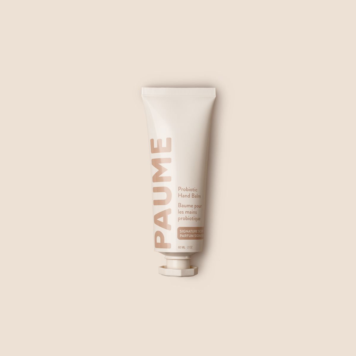 A squeeze tube of PAUME Probiotic Hand Balm on a solid light beige background.