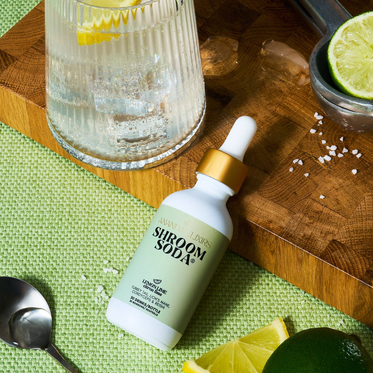 Shroom Soda Lemon Lime bottle on a wooden cutting board with lemon and lime slices.