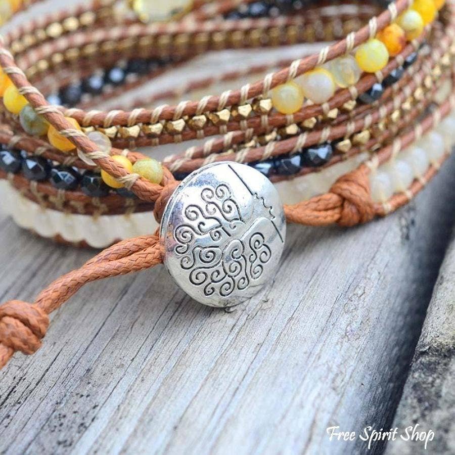 Multistrand bracelet with a silver bead on a wooden surface, featuring Free Spirit Shop branding.