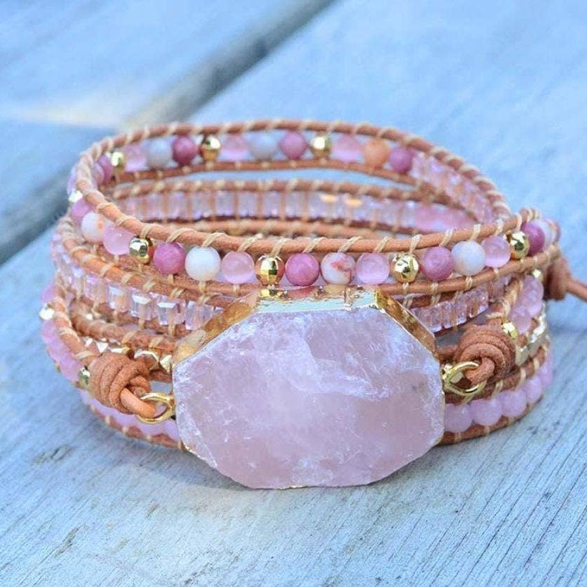Beaded bracelet with a large pink stone on a light wooden surface