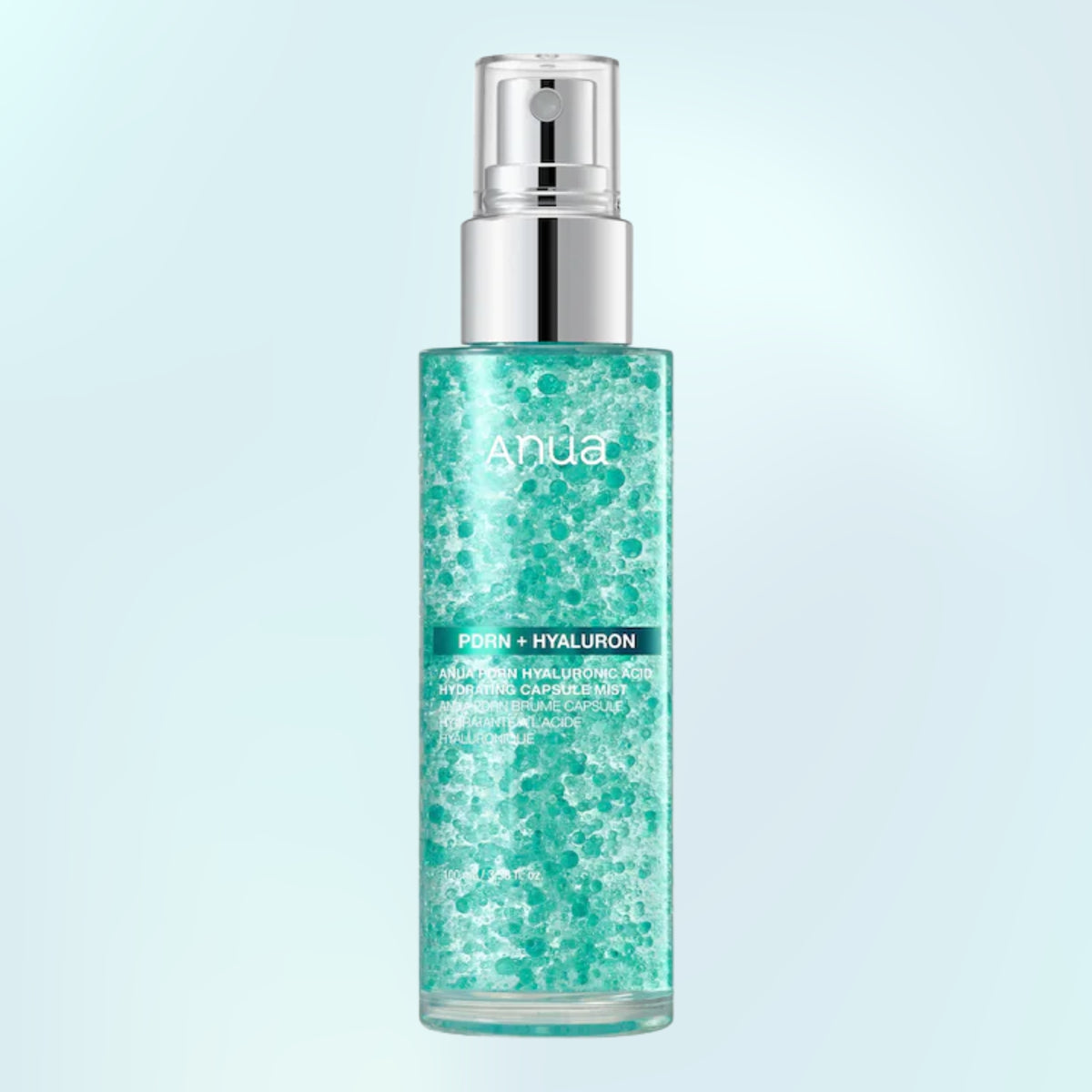 ANUA PDRN + Hyaluron skincare mist in a clear cylindrical bottle with a silver pump, filled with a sparkling teal-green liquid, set against a light blue gradient background.