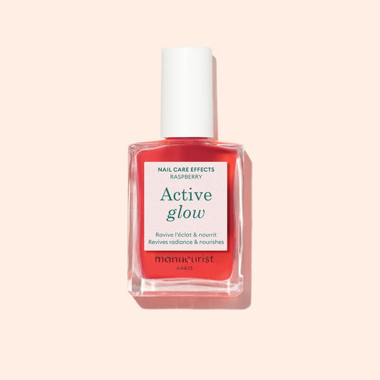 Manucurist Active Glow Raspberry 15 mL bottle on a pale peach background