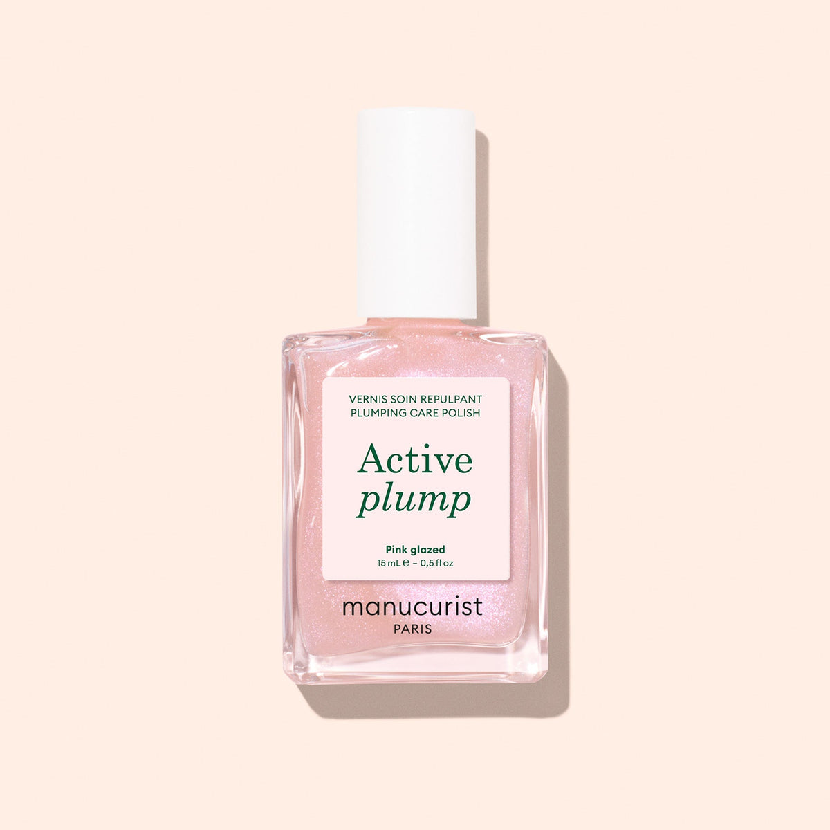 Manucurist Active Plump 15 mL bottle on a pale peach background