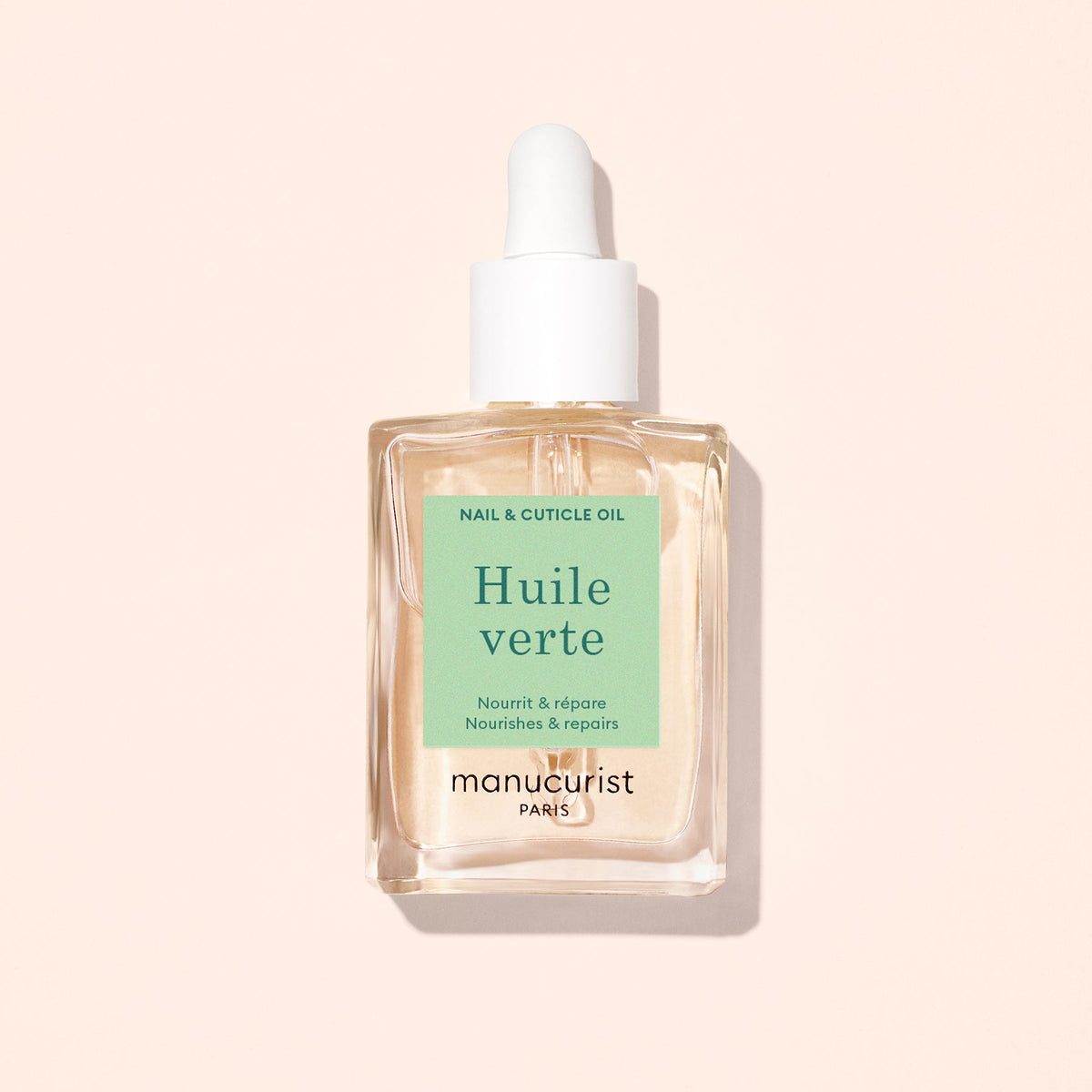 Manucurist Green Oil 15 mL bottle on a pale peach background