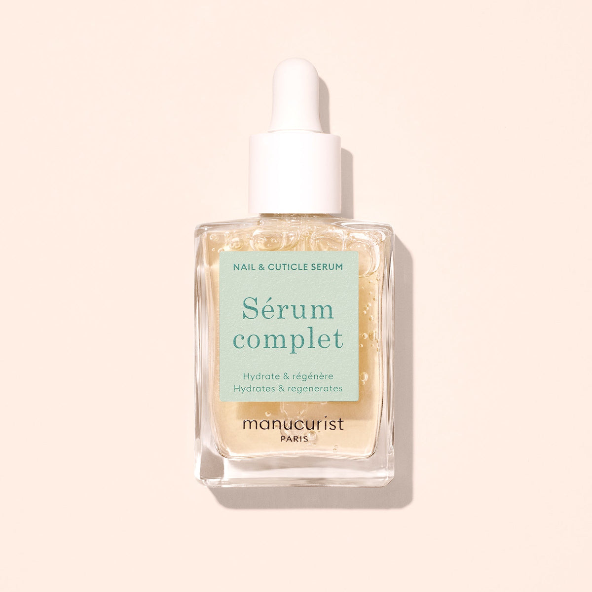 Manucurist Complete Serum 15 mL bottle on a pale peach background