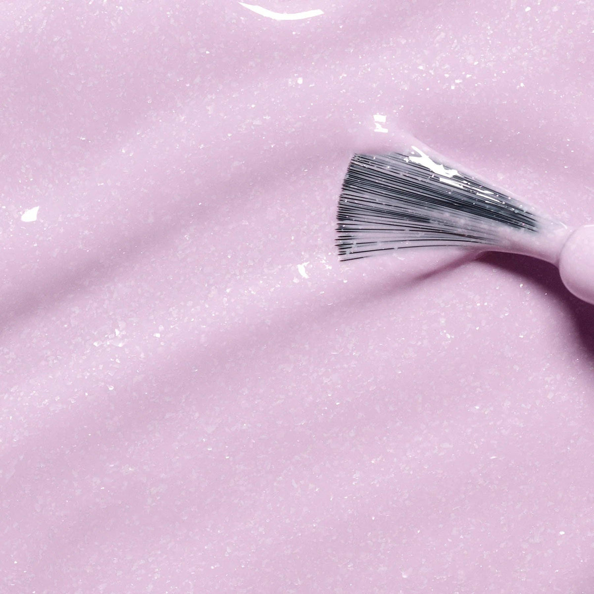 Janis mauve glitter nail polish with a brush on a mauve shimmer background
