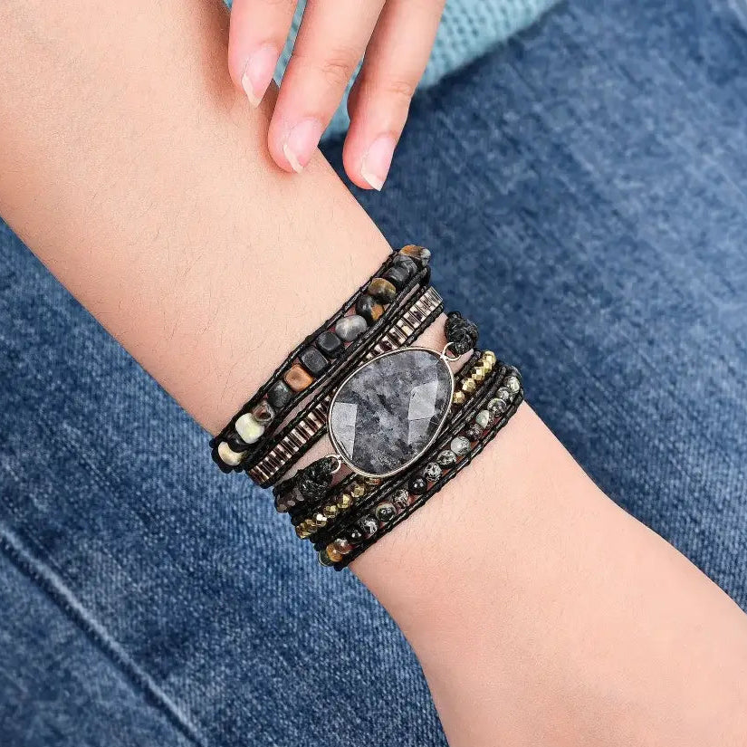 Stacked bracelets on a wrist with a denim background