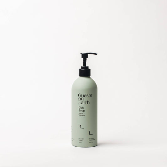 Guests on Earth Dish Soap in a pale green bottle with a black pump on a white surface.