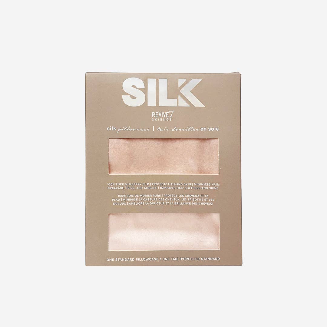 A rectangular beige product box for REVIVE7 SILK silk pillowcases, featuring two clear windows displaying the pale pink pillowcases inside, set against a light gray background.
