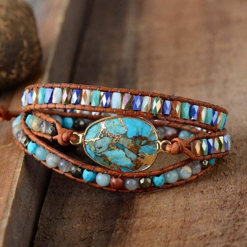 Multistrand beaded bracelet with a large turquoise stone on a wooden surface