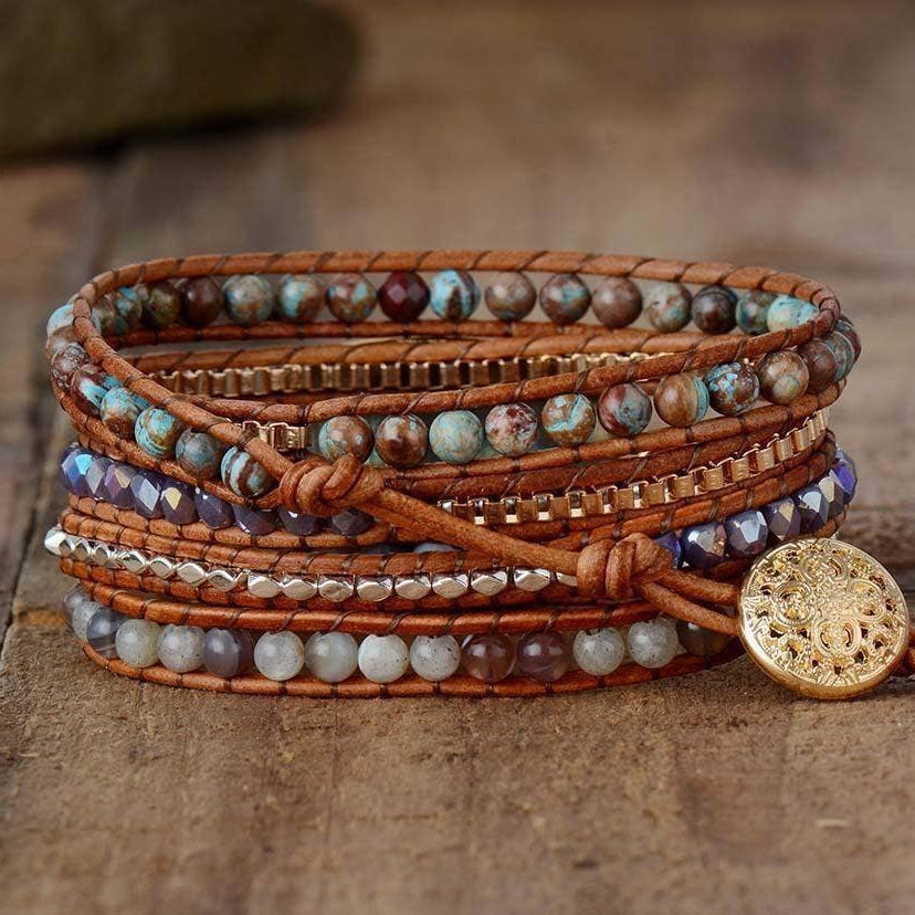 Multistrand beaded bracelet with a gold button clasp on a wooden surface.