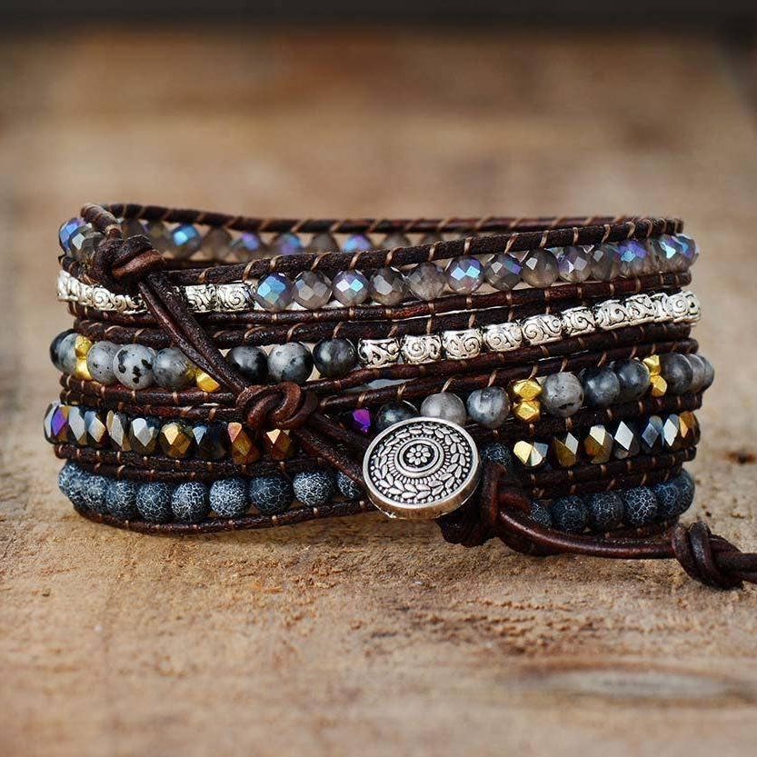 Multistrand beaded bracelet with decorative button clasp on a wooden surface.