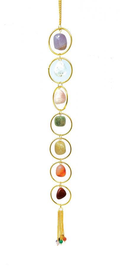 Chakra stone hanging with colorful stones and a tassel on a white background