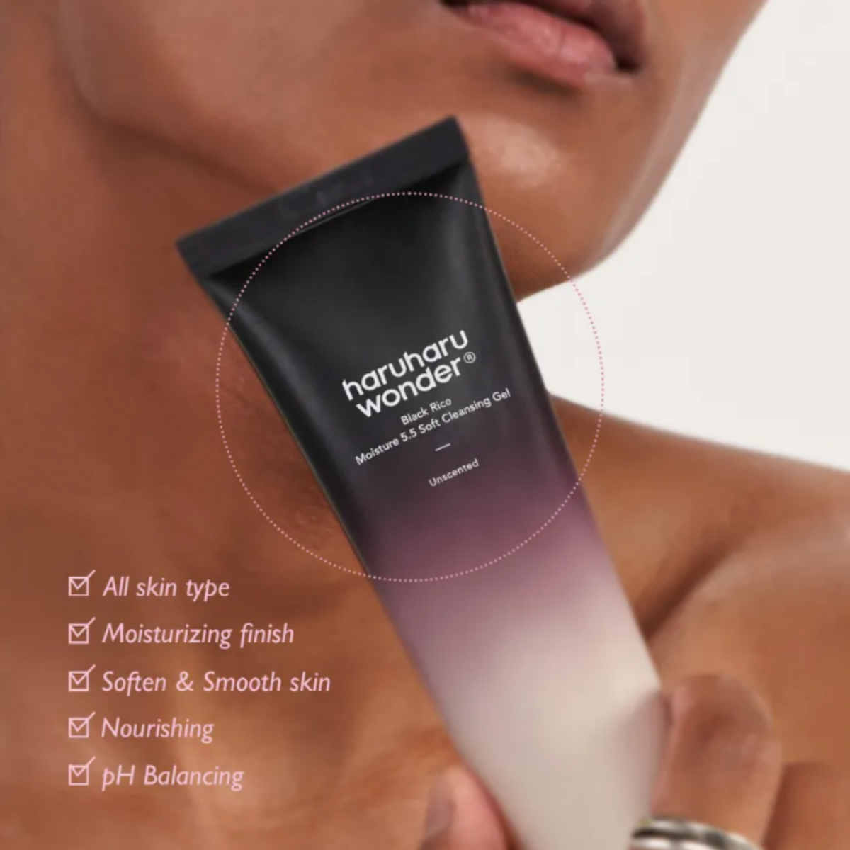 A close-up of a person holding a tube of haruharu wonder - Black Rice Moisture 5.5 Soft Cleansing Gel, with a list of product benefits overlaid on the left side. The tube features a black-to-purple-to-white gradient design.