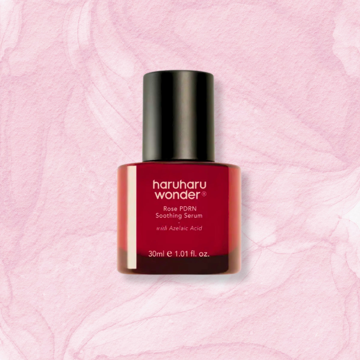 A bottle of haruharu wonder Rose PDRN Soothing Serum with Azelaic Acid, featuring a deep red bottle and a black cap, centered on a textured light pink background.