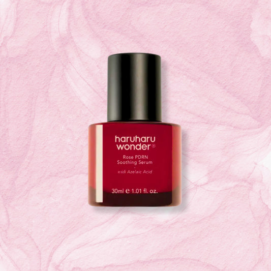 A bottle of haruharu wonder Rose PDRN Soothing Serum with Azelaic Acid, featuring a deep red bottle and a black cap, centered on a textured light pink background.