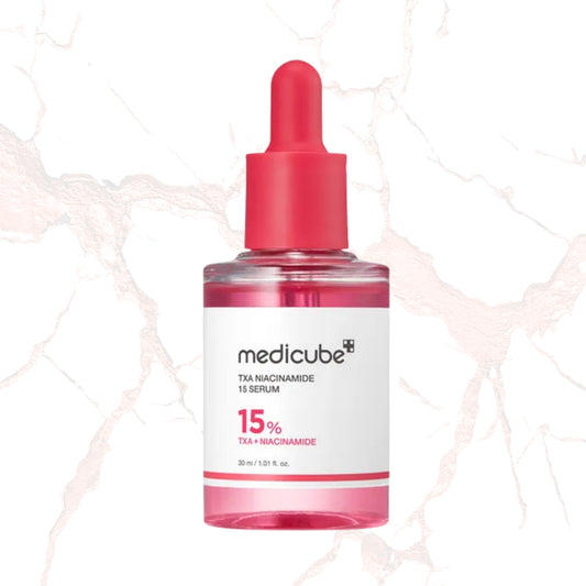 A 30 ml dropper bottle of medicube TXA Niacinamide 15 Serum, featuring a vibrant pink liquid inside a clear bottle with a bright pink dropper cap and a white label.