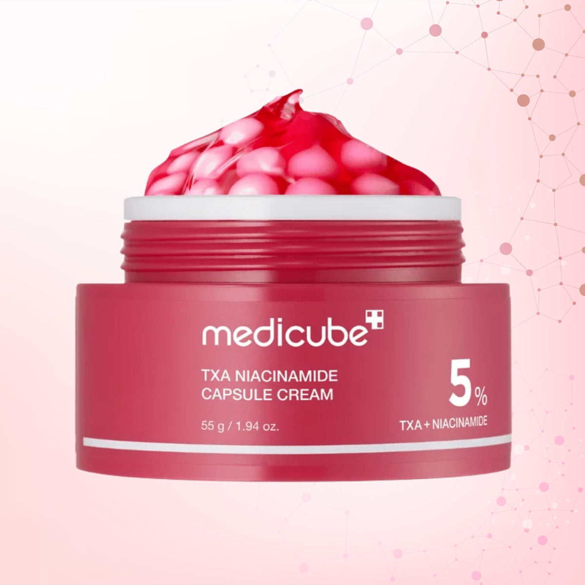 A jar of medicube TXA Niacinamide Capsule Cream with a red lid and a scoop of pinkish-red cream on top, set against a light pink background with subtle molecule graphics.