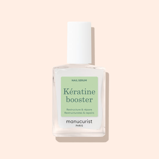 Manucurist Keratin Booster 15 mL bottle on a pale peach background